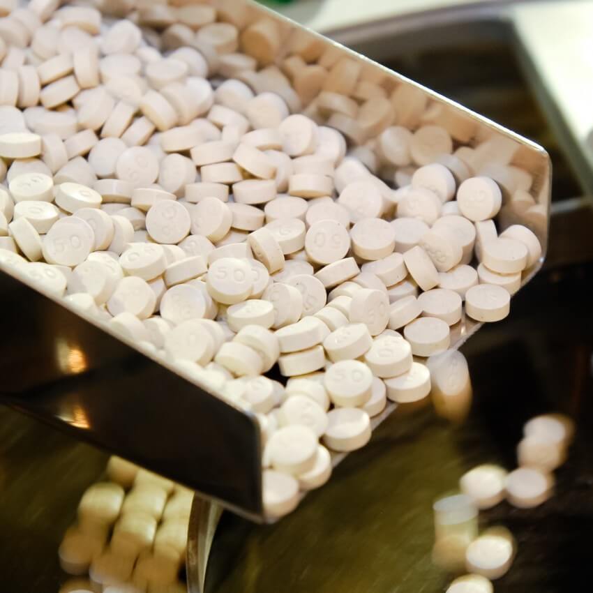 Closeup of pharmaceutical medicine tablet pill production.